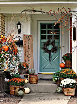 fall porch with orange turquoise and white mums, pumpkins